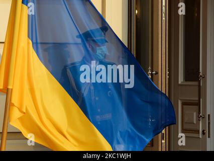 Il soldato della Guardia d'onore è coperto da una bandiera all'ingresso della residenza cerimoniale ufficiale del palazzo del presidente dell'Ucraina Mariyinsky prima della cerimonia di giuramento dei futuri ufficiali dell'esercito a Kiev, Ucraina, prima mattina 14 ottobre 2020. Diverse centinaia di studenti hanno prestato giuramento solenne nel liceo militare di Ivan Bohun Kyiv (Foto di Sergii Kharchenko/NurPhoto) Foto Stock