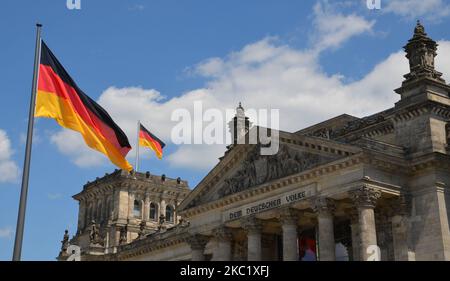 Bandiere tedesche davanti e in cima al tedesco 'Reichstag' con la scritta 'al popolo tedesco' Foto Stock