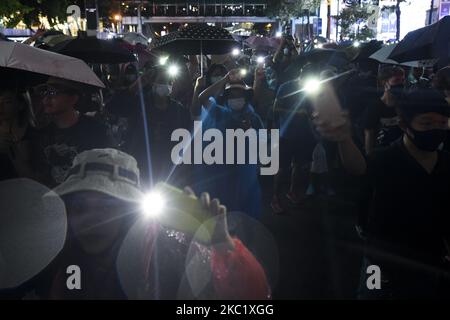 I manifestanti thailandesi tengono accese le torce sui telefoni durante i rally contro lo stato di emergenza nel quartiere commerciale di Ratchaprasong a Bangkok, Thailandia, 15 ottobre 2020. (Foto di Anusak Laowilas/NurPhoto) Foto Stock