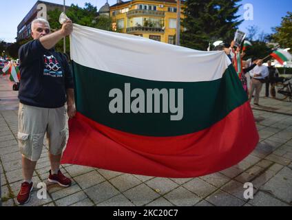 I manifestanti detengono una bandiera nazionale bulgara mentre partecipano al 100th° giorno di protesta anti-governativa al di fuori del Municipio di Burgas. I bulgari hanno manifestato a Sofia e in tutto il paese per 100 sere consecutive, chiedendo le dimissioni del primo ministro Boyko Borissov e del procuratore generale Ivan Geshev. Venerdì 16 ottobre 2020 a Burgas, Bulgaria. (Foto di Artur Widak/NurPhoto) Foto Stock