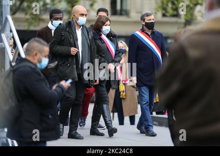 Il sindaco di Parigi Anne Hidalgo (3R) e il capo della ONG antirazzista SOS racisme Dominique Sopo (4R) arrivano mentre le persone si riuniscono in Place de la Republique a Parigi il 18 ottobre 2020, In omaggio all'insegnante di storia Samuel Paty due giorni dopo è stato decapitato da un attaccante che è stato ucciso a colpi di arma da fuoco dai poliziotti. Migliaia di persone si radunano a Parigi e in altre città francesi il 18 ottobre in uno spettacolo di solidarietà e di sfida dopo che un insegnante è stato decapitato per mostrare agli studenti cartoni animati del Profeta Maometto. Il suo assassinio in un sobborgo di Parigi il 16 ottobre ha scioccato il paese e ha riportato alla memoria un'ondata di violino islamista Foto Stock