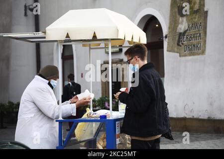 Una donna indossa una maschera facciale mentre vende pretzel alla piazza principale durante la pandemia di coronavirus. Cracovia, Polonia il 18th ottobre 2020. A causa della crescente diffusione del COVID-19 in Polonia, l'intero territorio del paese è designato come zona " gialla " e 152 contee e città, compresa Cracovia, sono contrassegnate come rosse a partire dall'ottobre 17. (Foto di Beata Zawrzel/NurPhoto) Foto Stock