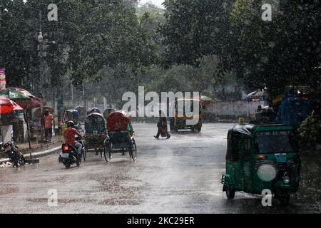 La gente si fa strada durante le precipitazioni a Dhaka, Bangladesh, il 21 ottobre 2020. (Foto di Rehman Asad/NurPhoto) Foto Stock