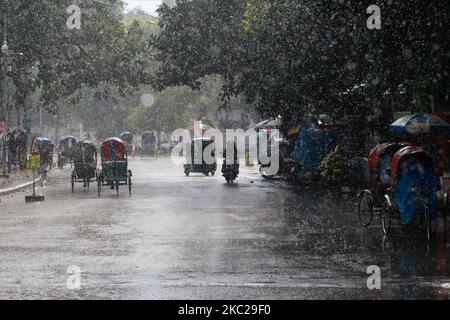 La gente si fa strada durante le precipitazioni a Dhaka, Bangladesh, il 21 ottobre 2020. (Foto di Rehman Asad/NurPhoto) Foto Stock