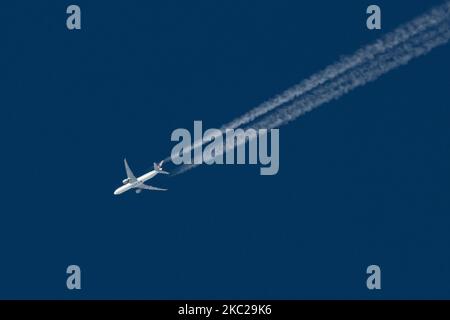 Aereo commerciale Qatar Airways Boeing 777-300ER con il logo della scritta QATAR visibile sul ventre e sul lato della fusoliera dell'aereo, sovravolare che forma lo scarico del motore contrasta dietro in alta quota a 38,000 metri nel cielo blu. L'iconico Boeing triplo sette come visto il 21 ottobre 2020 a Eindhoven, Paesi Bassi nello spazio aereo dell'Europa sopra i Paesi Bassi, in quanto sta volando una rotta a lungo raggio dall'aeroporto di Doha DOH in Qatar a Londra Heathrow LHR nel Regno Unito, volo QR7 / QTR4LA. L'aereo di sorvolo è un Boeing 777 o B773 con registrazione A7-BEH e sta volando WIT Foto Stock