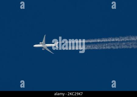 Aereo commerciale Qatar Airways Boeing 777-300ER con il logo della scritta QATAR visibile sul ventre e sul lato della fusoliera dell'aereo, sovravolare che forma lo scarico del motore contrasta dietro in alta quota a 38,000 metri nel cielo blu. L'iconico Boeing triplo sette come visto il 21 ottobre 2020 a Eindhoven, Paesi Bassi nello spazio aereo dell'Europa sopra i Paesi Bassi, in quanto sta volando una rotta a lungo raggio dall'aeroporto di Doha DOH in Qatar a Londra Heathrow LHR nel Regno Unito, volo QR7 / QTR4LA. L'aereo di sorvolo è un Boeing 777 o B773 con registrazione A7-BEH e sta volando WIT Foto Stock