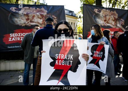 Attivisti pro-aborto con manifesti di sciopero delle donne accanto a striscioni anti-aborto, mentre la Corte costituzionale stava decidendo di vietare gli aborti per le indicazioni fetali, a Varsavia, Polonia, il 22 ottobre 2020. Al di fuori del tribunale, attivisti di entrambe le parti si sono riuniti in preghiera per i giudici per introdurre il divieto o per protestare contro la limitazione dei diritti riproduttivi delle donne. (Foto di Piotr Lapinski/NurPhoto) Foto Stock