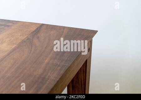 Particolare di un giunto in legno incollato di una gamba per sedie. Il materiale utilizzato per lo sgabello è il legno di ciliegio Foto Stock