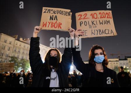 L'attivista tiene cartelli che dicono (L-R) 'noi meritiamo Una scelta' e '22.10.2020. Le donne polacche non vi perdonano per questo”. Migliaia di persone hanno marciato stasera a Cracovia e in altre città polacche per il terzo giorno consecutivo alle proteste contro il divieto quasi totale di aborto. La protesta è una reazione diretta alla sentenza di giovedì della Corte Suprema polacca secondo cui la legge esistente che autorizza la cessazione della gravidanza per il feto è contraria alla costituzione, inasprendo di fatto uno dei più severi regimi di aborto in Europa. Sabato 24 ottobre 2020 a Cracovia, Polonia. (Foto di Artur Widak/NurPhoto) Foto Stock