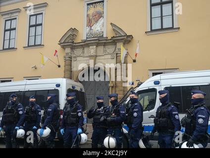 I membri della polizia proteggono l'ingresso al Palazzo Vescovile, sede della Curia Metropolitana di Cracovia. Migliaia di persone di tutte le età hanno marciato di nuovo a Cracovia e in altre città polacche per il quarto giorno di fila in una serie di proteste contro la nuova legge sull'aborto. La protesta è una reazione diretta alla sentenza di giovedì della Corte Suprema polacca secondo cui la legge esistente che autorizza la cessazione della gravidanza per il feto è contraria alla costituzione, inasprendo di fatto uno dei più severi regimi di aborto in Europa. Il 25 ottobre 2020, a Cracovia, Polonia. (Foto di Artur Widak/NurPhoto) Foto Stock