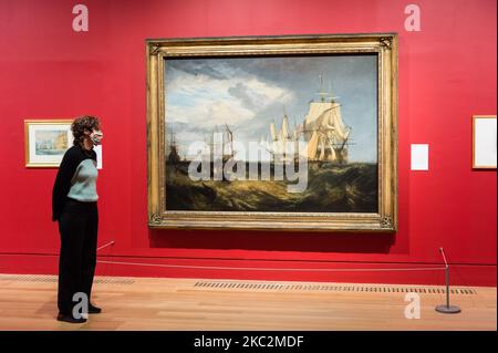 (SOLO PER USO EDITORIALE) Un membro dello staff della galleria pone accanto a 'Spihead: Due navi danesi catturate che entrano a Portsmouth Harbour', 1807–9 di JMW Turner (1775-1851) nel corso di una fotocall per promuovere l'apertura della mostra 'Turner's Modern World' a Tate Britain (28 ottobre 2020 - 7 marzo 2021) dedicata al più grande pittore paesaggistico britannico, il 26 ottobre 2020 a Londra, Inghilterra. (Foto di Wiktor Szymanowicz/NurPhoto) Foto Stock