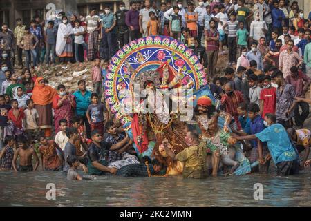I devoti indù immergono un idolo della dea Indù Durga nel fiume Buriganga durante l'ultimo giorno del festival Durga Puja a Dhaka il 26 ottobre 2020. Il festival di cinque giorni 'Durga Puja' commemora l'uccisione del re demone Mahishasura da parte della dea Indù Durga, segnando il trionfo del bene sul male. (Foto di Ahmed Salahuddin/NurPhoto) Foto Stock