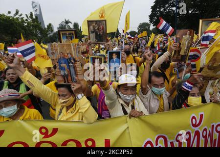 I pro-reali indossano camicie gialle mentre tengono ritratti della famiglia reale tailandese durante una monarchia di sostegno al parco Lumpini di Bangkok il 27 ottobre 2020. (Foto di Chaiwat Subprasom/NurPhoto) Foto Stock