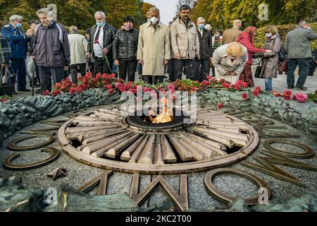 La gente deposita fiori e mostra il loro rispetto nella Tomba del Milite Ignoto a Kiev, in Ucraina, il 28 ottobre 2020 per celebrare il 76th° anniversario della liberazione dagli invasori nazisti nella seconda guerra mondiale. (Foto di Celestino Arce/NurPhoto) Foto Stock