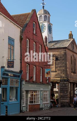 Traditional Jet Shops along Church Street with the Town Hall Clock Whitby North Yorkshire England Stock Photo