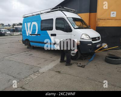 Lavoratore changin uno pneumatico nel camper auto-convertito Opel Movano con enorme luce barra a LED sul portapacchi durante il cambio di pneumatico stagionale sollevato sugli ascensori officina nel servizio pneumatici è visto a Danzica, Polonia il 2 ottobre 2020 (Foto di Michal Fludra/NurPhoto) Foto Stock