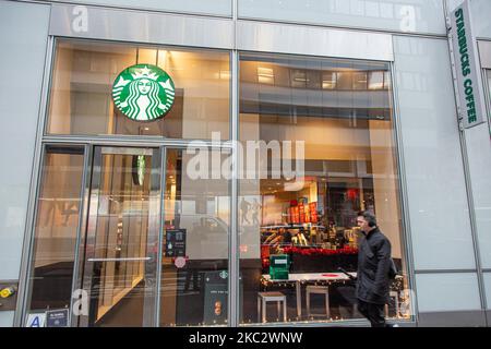 Un negozio di fronte a uno Starbucks Coffee Shop situato nel centro di Manhattan con persone a piedi. Starbucks Corporation è la più grande catena di caffetterie del mondo, una catena di caffè multinazionale americana con sede a Seattle, Washington. New York, Stati Uniti d'America il 2020 febbraio (Foto di Nicolas Economou/NurPhoto) Foto Stock