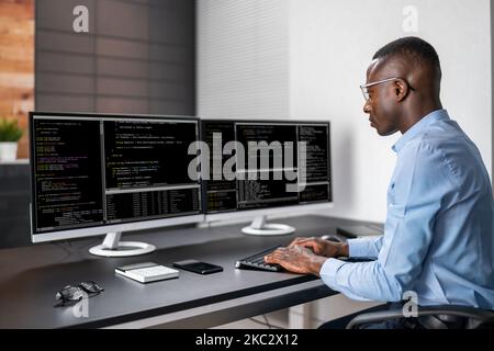 Codificatore afroamericano che usa il computer alla scrivania. Sviluppatore Web Foto Stock