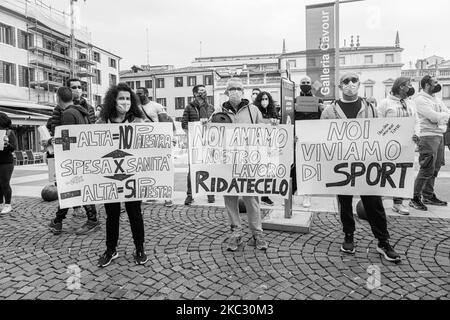 (NOTA DELL'EDITORE: L'immagine è stata convertita in bianco e nero) operai del mondo dello sport, proprietari di palestre e scuole di danza, posando in Piazza Cavour con cartelli contro il nuovo DPCM. Il 30 ottobre 2020, a Padova, Italia. Il nuovo DPCM emesso dal Premier Giuseppe Conte e attivo dal 26 ottobre 2020 prevede la chiusura di palestre e piscine, considerate luoghi di ritrovo sociale e quindi a rischio di contagio Covid19, e la chiusura anticipata a 18,00 dei bar e di altre attività di ristorazione. Ciò ha sollevato il generale malcontento delle varie categorie di lavoro coinvolte che oggi hanno preso Foto Stock