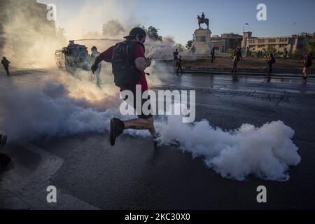 Una persona prende a calci una bomba lacrimogena rilasciata dalla polizia antisommossa dei carabineros de Chile (COP) il 30 ottobre 2020 a Santiago de Chile, Cile. In mezzo alla manifestazione e alla protesta per la libertà dei prigionieri politici dalla rivolta sociale in Cile. Contro il governo di Sebastian Pinera, la disuguaglianza sociale e il sistema neoliberale. (tra le altre cause). (Foto di Claudio Abarca Sandoval/NurPhoto) Foto Stock