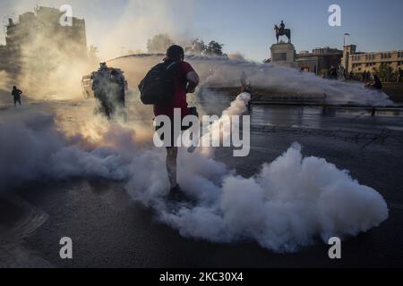 Una persona prende a calci una bomba lacrimogena rilasciata dalla polizia antisommossa dei carabineros de Chile (COP) il 30 ottobre 2020 a Santiago de Chile, Cile. In mezzo alla manifestazione e alla protesta per la libertà dei prigionieri politici dalla rivolta sociale in Cile. Contro il governo di Sebastian Pinera, la disuguaglianza sociale e il sistema neoliberale. (tra le altre cause). (Foto di Claudio Abarca Sandoval/NurPhoto) Foto Stock