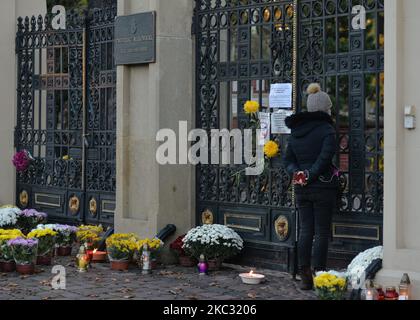 Una donna guarda attraverso il cancello d'ingresso al cimitero di Rakowicki a Cracovia. Sabato la Polonia ha riportato un quinto record giornaliero consecutivo per nuovi casi di coronavirus, con 21.897 nuove infezioni. Il primo Ministro Mateusz Morawiecki ha annunciato venerdì pomeriggio che i cimiteri rimarranno chiusi da sabato 31 ottobre a lunedì 2 novembre. La decisione del governo ha colpito la gente che fa una vita dalla produzione e dalla vendita delle candele e dei fiori. Sabato 31 ottobre 2020 a Cracovia, Polonia. (Foto di Artur Widak/NurPhoto) Foto Stock