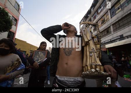 I devoti di Santa Muerte vengono a visitarla prima della serata nel quartiere ruvido di Tepito a Città del Messico, Messico, il 31 ottobre 2020. Questo consiste in una preghiera e gratitudine prima della più grande festa di questa immagine che si celebra il 1 novembre. Ed è che, questo altare è stato posto 19 anni fa, che è il più visitato nel centro di Città del Messico. (Foto di Martin Gorostiola/NurPhoto) Foto Stock