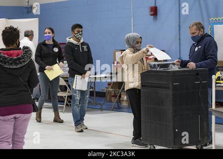 Il primo elettore Marwah al Thuwayni, di 18 anni, lancia il suo voto. Era una di circa 1000 persone che si è registrata per votare al luogo di scrutinio del Bishop Leo E. ONeil Youth Center a Manchester, New Hampshire, il giorno delle elezioni. Il luogo di voto di Ward 9 è stato uno dei più trafficati della città, poiché gli elettori si sono affrettati a votare alle elezioni presidenziali del 3 novembre 2020. (Foto di Jodi Hilton/NurPhoto) Foto Stock