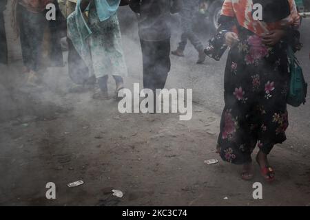 La gente si muove mentre la plastica bruciante genera il fumo tossico vicino ad una strada in Dhaka, Bangladesh giovedì 05 novembre 2020. Secondo uno studio, l'inquinamento atmosferico riduce di 7 anni l'aspettativa di vita. (Foto di Syed Mahamudur Rahman/NurPhoto) Foto Stock