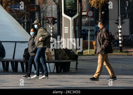 Vita quotidiana nella città di Eindhoven nei Paesi Bassi con persone che indossano maschere facciali mentre sono fuori a piedi o in bicicletta, utilizzando il facemask come misura protettiva contro la diffusione della pandemia di Coronavirus Covid-19. Paesi Bassi da martedì 13 ottobre 2020, quando il primo ministro olandese Mark Rutte ha annunciato che il paese va in una chiusura parziale, la chiusura dei bar e ristoranti, l'uso obbligatorio di maschera facciale al chiuso, la limitazione al numero di persone che si riuniscono al chiuso, attività sportive e altro ancora sono interessati. Il paese è stato uno dei principali focolai in Europa. Eind Foto Stock