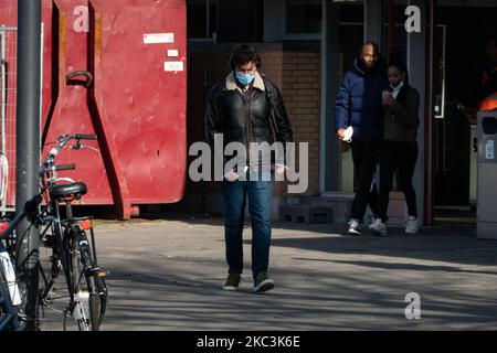 Vita quotidiana nella città di Eindhoven nei Paesi Bassi con persone che indossano maschere facciali mentre sono fuori a piedi o in bicicletta, utilizzando il facemask come misura protettiva contro la diffusione della pandemia di Coronavirus Covid-19. Paesi Bassi da martedì 13 ottobre 2020, quando il primo ministro olandese Mark Rutte ha annunciato che il paese va in una chiusura parziale, la chiusura dei bar e ristoranti, l'uso obbligatorio di maschera facciale al chiuso, la limitazione al numero di persone che si riuniscono al chiuso, attività sportive e altro ancora sono interessati. Il paese è stato uno dei principali focolai in Europa. Eind Foto Stock