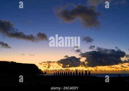 Una silhouette delle statue di moai sullo sfondo di un tramonto sull'Isola di Pasqua Foto Stock