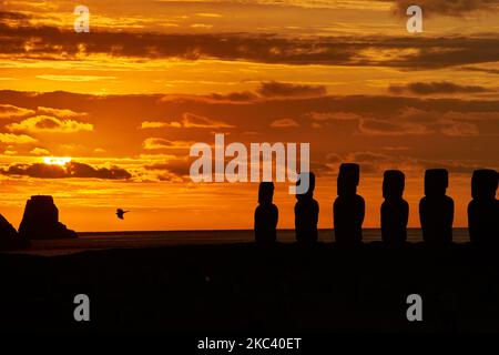 A silhouette shot of the moai statues over a background of a golden sunset at Easter Island Foto Stock