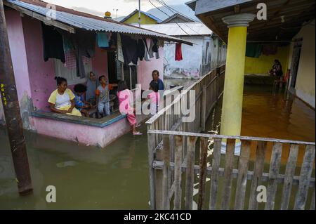 I residenti hanno attività nelle loro case che sono state inondate dalle inondazioni nel villaggio di Lere, Palu, Provincia di Sulawesi Centrale, Indonesia il 14 novembre 2020. Oltre ad essere causato da alte maree, alluvioni che si verificano per cinque giorni ogni mese, è anche causato da subsidence di terra fino a 1,5 metri a causa del terremoto di magnitudo 7,4 due anni fa sulla costa di Palu Bay. Il terremoto che ha scatenato lo tsunami e la liquefazione ha ucciso più di 5.000 residenti. (Foto di Basri Marzuki/NurPhoto) Foto Stock