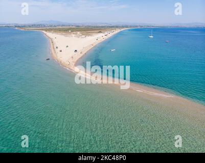 Veduta aerea dell'esotica Potamos - Epanomi Beach Sandbank vicino alla città di Salonicco come visto da un drone durante l'era pandemica Coronavirus Covid-19 con misure di allontanamento sociale applicate. Alcuni ombrelloni e persone si vedono rilassarsi in spiaggia con le acque cristalline del Mar Egeo e del Mediterraneo. La spiaggia di Epanomi è vicina alla città e all'aeroporto, famosa per la spiaggia di sabbia tropicale, le dune, il naufragio, la riva del sabbia e i bar sulla spiaggia. Il numero di turisti e visitatori in Grecia e in tutto il mondo è sceso durante l'era pandemica, colpendo l'industria del turismo. E Foto Stock