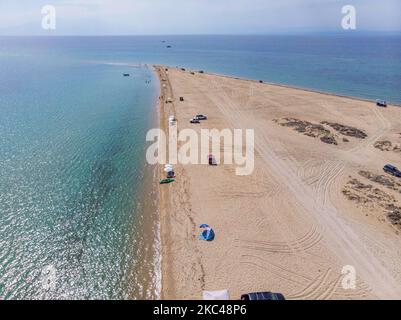 Veduta aerea dell'esotica Potamos - Epanomi Beach Sandbank vicino alla città di Salonicco come visto da un drone durante l'era pandemica Coronavirus Covid-19 con misure di allontanamento sociale applicate. Alcuni ombrelloni e persone si vedono rilassarsi in spiaggia con le acque cristalline del Mar Egeo e del Mediterraneo. La spiaggia di Epanomi è vicina alla città e all'aeroporto, famosa per la spiaggia di sabbia tropicale, le dune, il naufragio, la riva del sabbia e i bar sulla spiaggia. Il numero di turisti e visitatori in Grecia e in tutto il mondo è sceso durante l'era pandemica, colpendo l'industria del turismo. E Foto Stock