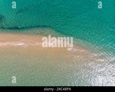 Veduta aerea dell'esotica Potamos - Epanomi Beach Sandbank vicino alla città di Salonicco come visto da un drone durante l'era pandemica Coronavirus Covid-19 con misure di allontanamento sociale applicate. Alcuni ombrelloni e persone si vedono rilassarsi in spiaggia con le acque cristalline del Mar Egeo e del Mediterraneo. La spiaggia di Epanomi è vicina alla città e all'aeroporto, famosa per la spiaggia di sabbia tropicale, le dune, il naufragio, la riva del sabbia e i bar sulla spiaggia. Il numero di turisti e visitatori in Grecia e in tutto il mondo è sceso durante l'era pandemica, colpendo l'industria del turismo. E Foto Stock