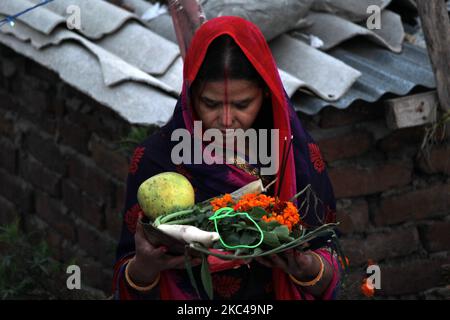 Una donna indù devotee eseguire rituali e adorare il dio Sole in uno stagno artificiale creato su strada o sul tetto durante il Chhath Puja festival a Nuova Delhi il 20 novembre 2020. Il governo di Delhi ha vietato le celebrazioni comunitarie di Chhath Puja sulle rive del fiume, sui ghati e sui templi, in un numero crescente di casi COVID-19. (Foto di Mayank Makhija/NurPhoto) Foto Stock