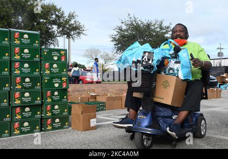 Un uomo su una sedia a rotelle motorizzata trasporta il cibo donato dalla seconda Harvest Food Bank della Florida centrale e dalla città di Orlando alla Jones High School il 20 novembre 2020 a Orlando, Florida. Con l'avvicinarsi del giorno del Ringraziamento, migliaia di famiglie nell'area di Orlando hanno bisogno di assistenza alimentare a causa dei massicci licenziamenti nei parchi a tema locali e nell'industria turistica. (Foto di Paul Hennessy/NurPhoto) Foto Stock