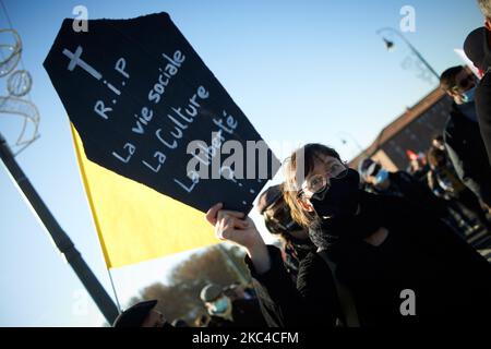 Una giovane donna tiene un cartello raffigurante una bara e leggendo 'RIP la vita sociale? La cultura? Libertà ?...' Migliaia di manifestanti sono scesi in piazza dopo la chiamata delle ONG (Amnesty International, Human Rights League), dei sindacati (CGT, CNT, FO, SAF vale a dire Unione degli avvocati francesi), i sindacati dei giornalisti (SNJ, SNJ-CGT) e i partiti politici per una protesta contro la cosiddetta legge sulla sicurezza globale promossa dal presidente francese Macron e dalla sua maggioranza. Hanno anche chiesto più mezzi per gli ospedali come la 2nd onda di Covid-19 è qui. Alcuni giubbotti gialli sono venuti anche per il 2nd ° anniversario di Foto Stock