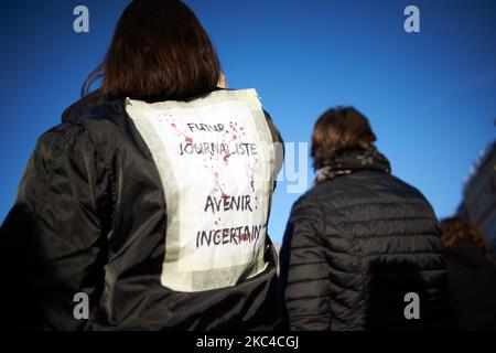 Una donna ha messo un foglio sul retro della sua lettura "futuro giornalista, futuro incerto”. Migliaia di manifestanti sono scesi in piazza dopo la chiamata delle ONG (Amnesty International, Human Rights League), dei sindacati (CGT, CNT, FO, SAF vale a dire Unione degli avvocati francesi), i sindacati dei giornalisti (SNJ, SNJ-CGT) e i partiti politici per una protesta contro la cosiddetta legge sulla sicurezza globale promossa dal presidente francese Macron e dalla sua maggioranza. Hanno anche chiesto più mezzi per gli ospedali come la 2nd onda di Covid-19 è qui. Alcuni giubbotti gialli sono venuti anche per il 2nd° anniversario della loro prima protesta. Il valore ma Foto Stock