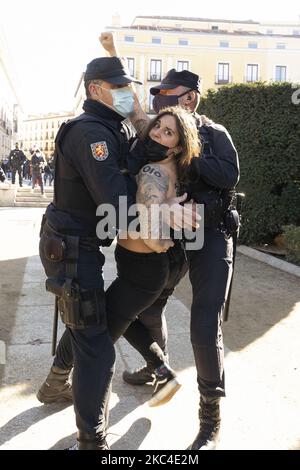 Attivista FEMEN, come è trattenuta dalla polizia quando protestava contro le celebrazioni fasciste prima dell'inizio di un rally che commemorava il 45th° anniversario della morte dell'ex dittatore spagnolo Francisco Franco a Plaza de Oriente il 22 novembre 2020 a Madrid, Spagna. Il generale Francisco Franco Bahamonde fu il dittatore della Spagna dal 1939, dopo la fine della guerra civile spagnola, fino alla sua morte nel 1975. (Foto di Oscar Gonzalez/NurPhoto) Foto Stock