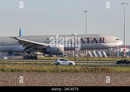 Qatar Airways l'aereo Boeing 777-300 visto all'arrivo finale, volando e atterrando vicino alla strada autostradale di Amsterdam Schiphol AMS EHAM nei Paesi Bassi, arrivando dall'aeroporto internazionale di Hamad DOH OTHH, la capitale del Qatar. L'aeroplano a lunga percorrenza con cassone largo, un Boeing B777 o 773, ha la registrazione A7-BEU ed è alimentato da 2x motori a reazione GE. Qatar QTR QR è il vettore nazionale di bandiera dello Stato del Qatar. La compagnia aerea è membro dell'alleanza aerea oneworld. Il Qatar non smetteva di volare durante la prima o la seconda ondata dell'epidemia, nonostante il fatto che il mondo passasse Foto Stock