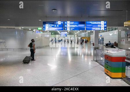 Passeggeri visti con le maschere facciali obbligatorie presso la sala principale delle partenze nel terminal dell'aeroporto internazionale di Atene ATH LGAV in Grecia. Molti paesi la Grecia ha incluso reintrodurre le misure di Coronavirus come blocco, quarantena e restrizioni di viaggio. I passeggeri che indossano maschere e guanti, utilizzano disinfettanti per le mani come misura preventiva contro la diffusione della pandemia COVID-19. La Grecia e l'Europa hanno chiuso a lungo i confini per le persone al di fuori dell'Europa e della zona Schengen, ma la Grecia ha iniziato a revocare il divieto di circolazione dal giugno 2020 per rilanciare l'economia, i viaggi e l'incudenza turistica Foto Stock