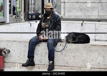 Un uomo che indossa una maschera protettiva siede accanto al suo animale domestico nel quartiere di Chiado, Lisbona. Novembre 23, 2020. Il Portogallo ha registrato 4.788 nuove infezioni da coronavirus e 73 decessi correlati al COVID-19. Secondo il bollettino pubblicato oggi dal Dipartimento della Salute Generale, il paese ha un totale complessivo di 3.897 morti dall'inizio della pandemia e di 260.758 casi. (Foto di Jorge Mantilla/NurPhoto) Foto Stock