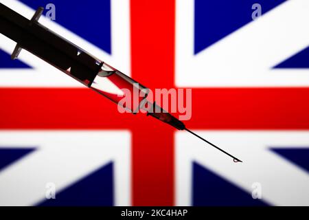 Siringa medica è visto con la bandiera britannica sullo sfondo in questa foto di illustrazione scattata in Polonia il 23 novembre 2020. (Foto di Jakub Porzycki/NurPhoto) Foto Stock