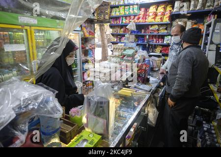 Una donna velata iraniana che indossa una maschera protettiva guarda mentre si acquista in un supermercato nel nord di Teheran il giorno 3 di due settimane di blocco totale il 24 novembre 2020. Il governo iraniano considera un blocco totale di due settimane a Teheran, ma le strade sono ancora occupate, un sacco di persone sul terreno che possono aumentare il numero di morti, ma sembra che la gente iraniana invece del COVID-19 sono per lo più preoccupati per l'economia. MORTEZA NIKOUBAZL/NurPhoto (Foto di Morteza Nikoubazl/NurPhoto) Foto Stock