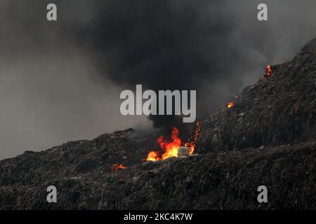 Una vista di fumo che si sgombera dopo un incendio scoppiato nella discarica Ghazipur di Delhi est a Nuova Delhi il 25 novembre 2020. Le stazioni di monitoraggio della qualità dell'aria nella parte orientale di Delhi, più vicine alla discarica, hanno evidenziato un notevole picco dei livelli di inquinamento. A Patparganj, i livelli erano 423 e ad Anand Vihar, la lettura AQI media ha girato fino a 445 a 1pm. (Foto di Mayank Makhija/NurPhoto) Foto Stock