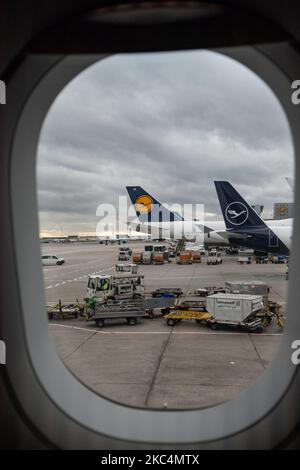 Linea di coda, fila di velivoli Lufthansa con il logo visibile da una finestra aerea dell'aeroporto internazionale di Francoforte fra. L'ex portatore di bandiera tedesco ha lì la più grande base hub. Deutsche Lufthansa AG è il più grande vettore aereo tedesco, il secondo per numero di passeggeri in Europa e membro dell'alleanza Star Alliance. Il marchio utilizza l'uccello della gru in cerchio come un logo, un simbolo negli anni che recentemente ha cambiato il marchio da giallo a bianco in blu. L'aeroporto di Francoforte è l'aeroporto più trafficato della Germania, 4th in Europa e 13th in tutto il mondo. Francoforte, Germania il 2020 marzo (Pho Foto Stock