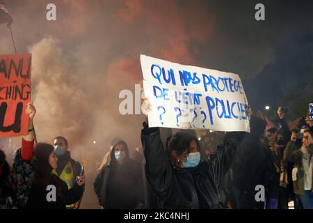 Una donna ha in mano un cartello con la scritta "Chi ci protegge da uno stato di polizia?" Migliaia di manifestanti sono scesi in piazza dopo la chiamata delle ONG (Amnesty International, Human Rights League), dei sindacati (CGT, CNT, FO, SAF vale a dire Unione degli avvocati francesi), i sindacati dei giornalisti (SNJ, SNJ-CGT) e i partiti politici per una protesta contro la cosiddetta legge sulla sicurezza globale promossa dal presidente francese Macron e dalla sua maggioranza. Il disegno di legge 'Global Security Law' inoltre proibirà a chiunque di fotografare o filmare i membri della polizia se non violati : i trasgressori potrebbero essere condannati fino a un anno in prigione e un Fi €45,000 Foto Stock